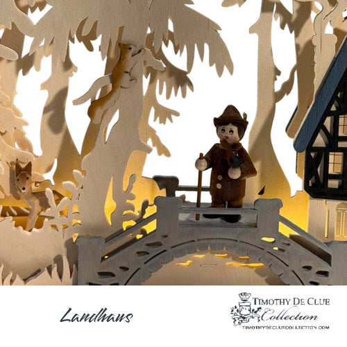 Landhaus Schwibbogen 699 wood cutout with illuminated forest scene and figure sitting by cottage.