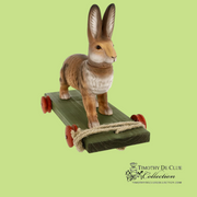 Bunny Pull Toy Vintage Inspired German Paper Mache, side view on green base with red wheels and rope