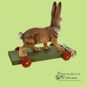 Bunny Pull Toy Vintage Inspired German Paper Mache, side view on green wooden base with red wheels
