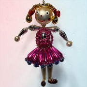 Liesel in Pink beaded Christmas ornament with metallic silver head, red bows, magenta beaded dress, and gold accents.