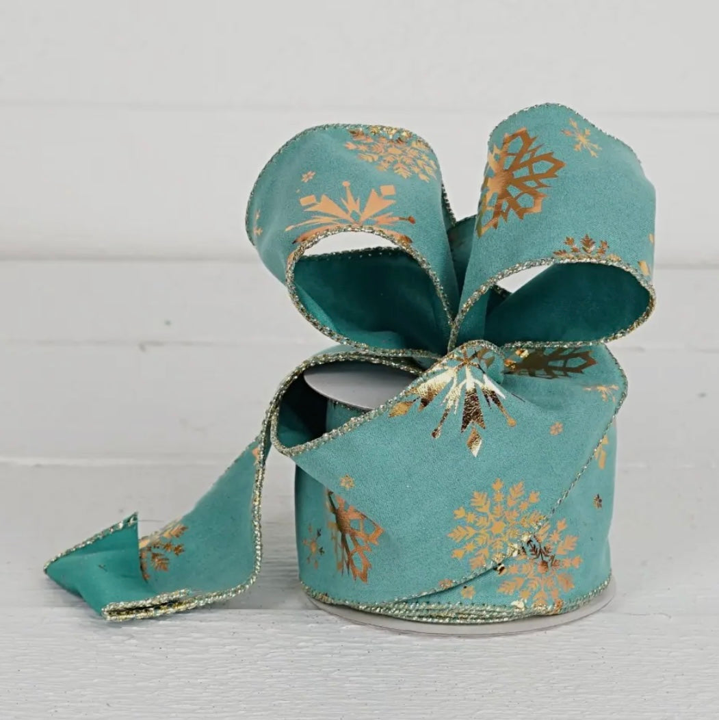 Aqua and Gold Snowflakes 2.5" Ribbon with gold glitter edges, coiled on white wooden surface