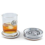 Concho Western Drink Coaster Set of 4, silver metal with cork base, one supporting whiskey glass with ice.