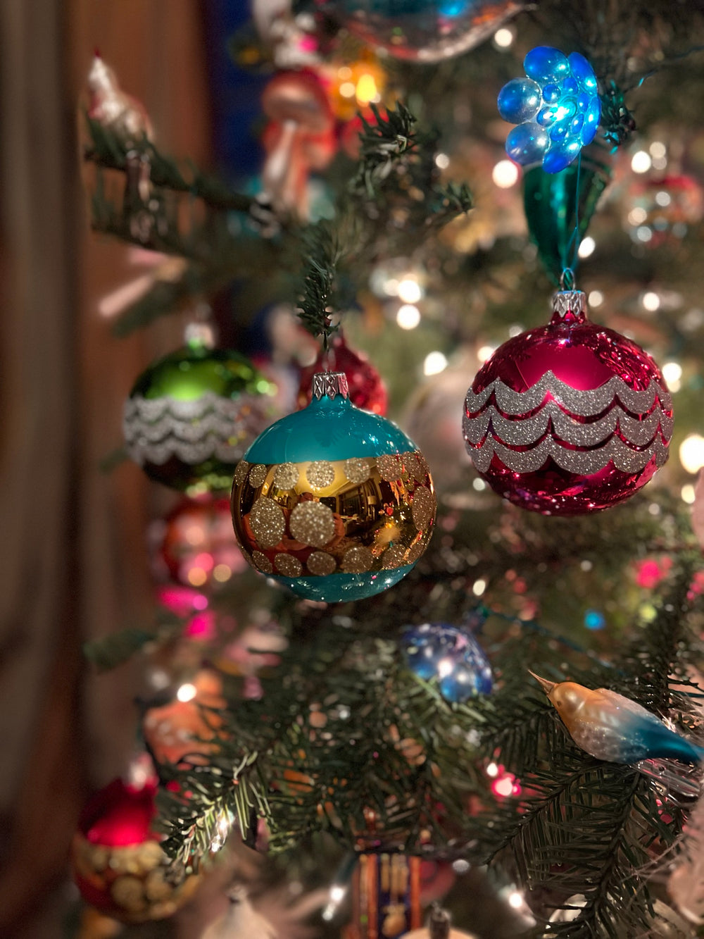 A white feather tree covered in ornaments on display in the showroom