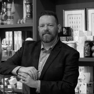 Timothy De Clue in front of shelves of home goods