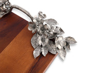 Bee and Flower Serving Tray, close-up of silver metal blooms and leaves on wooden corner.