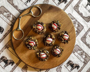 Equestrian Bit Cheese Board with red and cream striped ornaments, wooden round board, silver scissors.