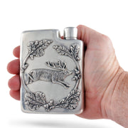 Black Forest Pewter Flask held in hand, showing embossed stag and oak leaf design